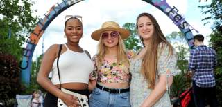 Ladies stood in front of the Cheltenham Jazz Festival sign in Montpellier Gardens, Cheltenham.