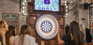 Group of people playing darts at Flight Club.