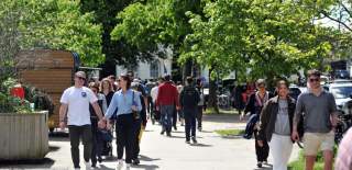 Visitors walking down The Promenade and Imperial Gardens in Cheltenham.
