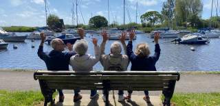 People sat on bench looking out across Christchurch Quay