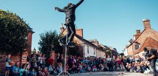 Man on unicycle in front of large crowd