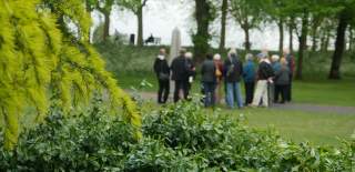 A Guided Walking Tour Group explore Colchester Castle Park.