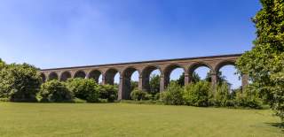 Chappel Viaduct surrounded by trees and blue skies