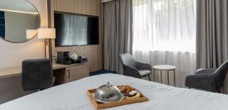 Interior of Marks Tey Hotel bedroom with a tray of food on the bed