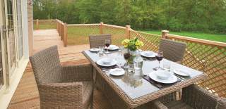 Table and chairs outside Wakes Hall Lodges with table laid with plates and wine