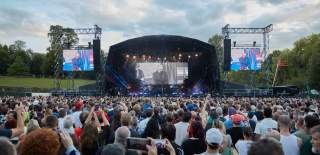 A crowd is formed in front of a large stage.
