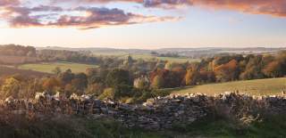 A Cotswold stone wall frames rolling autumnal countryside and the Abbotswood estate
