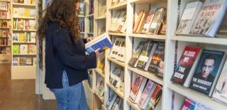 A woman browsing the books in Jaffe & Neale