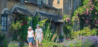 Broadway in the Summer- male and female walking in the Cotswold town of Broadway