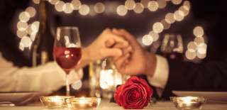 Holding hands over a romantic set table