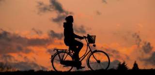 person cycling against the sun
