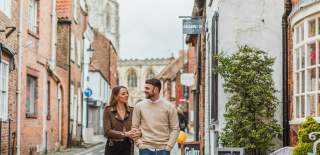 A couple walking arm in arm through the streets of Beverley town centre in East Yorkshire.