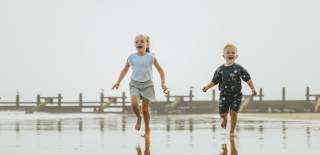 Two children running along the beach in Hornsea
