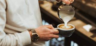 A close up of a barista making a coffee.