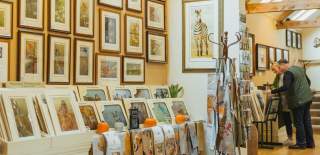 Two people browsing the artwork on display in the Robert Fuller Gallery in Thixendale