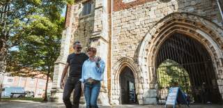A couple strolling in the sunshine in front of the Bayle Museum in Bridlington's Old Town in East Yorkshire