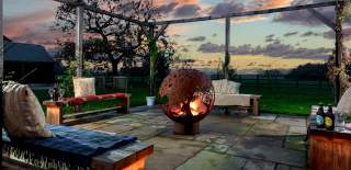 Outdoor patio with seating around a fire pit at Broadgate Farm in East Yorkshire