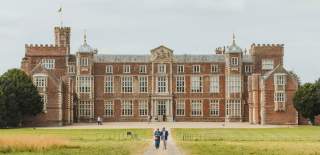 A couple walking with Burton Constable Hall in the background