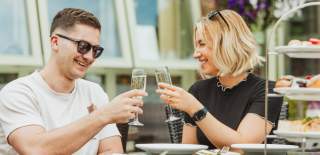 A couple clinking Champagne classes while they enjoy afternoon tea at Drewton's in East Yorkshire