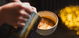 A close up of a barista's hands pouring a hot drink at Gemini Chocolate in Beverley.