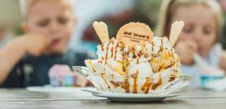 A huge ice cream sundae from Mr Moos in East Yorkshire. Two children can be seen in the background tucking into an ice cream too.