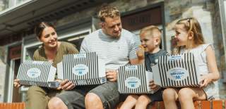 A family sat on a wall tucking into fish and chips from Whitehead's