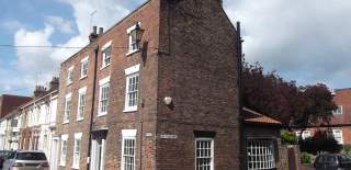 Grade II listed Georgian town house with white window frames located on street corner