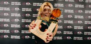 a winner holding the 2028 trophy in front of her