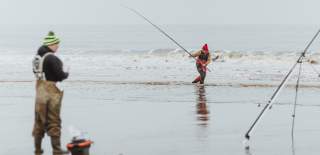 Anglers rebaiting and another in the shores casting the rod