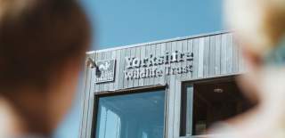Two children looking over to the Yorkshire Wildlife Trust visitor centre at Spurn Point Nature Reserve in East Yorkshire