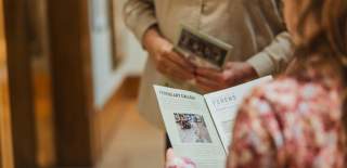 Two people in Ferens, holding a leaflet filled with information about the art.
