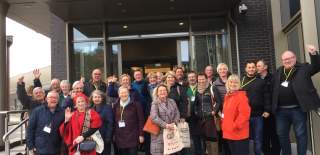 Group of visitors standing outside the DoubleTree by Hilton hotel entrance, gathered on the front steps during a group tour in Hull