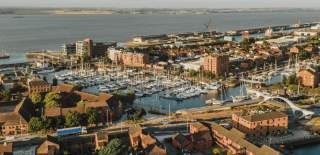 Aerial view of Hull Marina with boats, waterfront buildings, footbridge and the Humber Estuary in the background