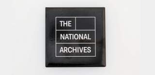 The National Archives Logo - The National Archives is written in white writing and each word is in an individual white box. The writing and square outlines are in a black square upon a white background.