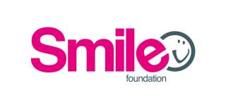 The HEY smile foundation logo. The word smile is in pink text with the word foundation underneath in smaller grey text. On the right there is a grey smiley face.