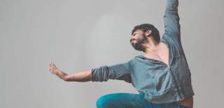 A man holds his arms out in a dance pose
