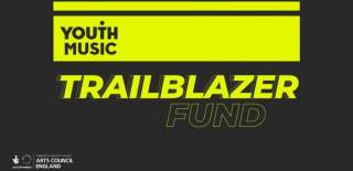 Youth Music Trailblazer Fund logo. The words Youth Music are along the top in a yellow rectangle. The word Trailblazer is underneath in yellow lettering with a slant on the text. The word Fund is underneath in grey lettering with a yellow outline.