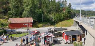 Turistkontoret Visit Indre Østfold - en liten rød bod på kaia i Ørje