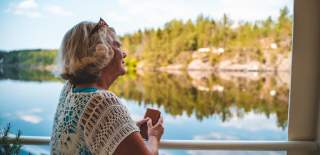 Eldre dame nyter utsikten på båttur i Brekke sluser