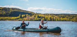 Two men are paddling a canoe in the lake.