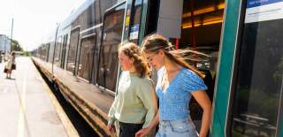 Two girls get off the train