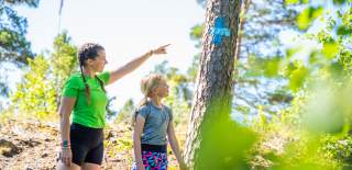 Two children follow a blue track in the forest in Ørje.