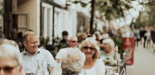 Glade mennesker på en uteservering i gågata i Sarpsborg. Foto