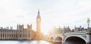 A view over the Thames as the sun sets behind the Elizabeth Tower of Big Ben