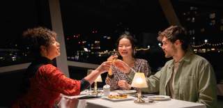 3 people enjoying drinks onboard City Cruises at night