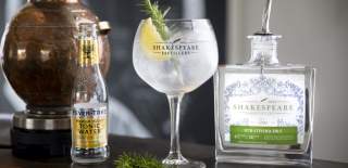 A gin and tonic next to a bottle of Stratford Gin by Shakespeare Distillery with a bottle of Fever Tree Tonic