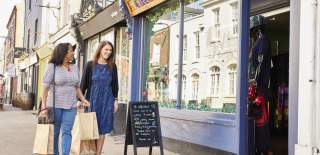Two people walking down Carlton Place with shopping bags