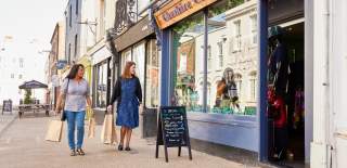 Two people walking past a shop in the pedestrain area of Carlton Place