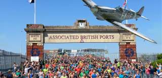 Spitfire flying above runners taking part at ABP Marathon