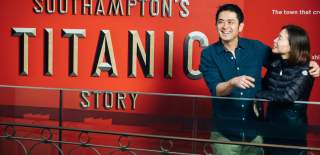 Two people stood in front of the Titanic Exhibition sign which reads Southampton's Titanic Story at Seacity Museum